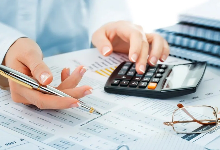 Accounting Assignment Help: Tackling Complexity with Calculator and Pen A student seeking help for an accounting complex assignment, using a calculator and pen to write on paper
