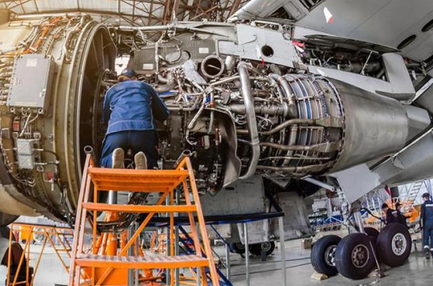 Precision in Progress: Aerospace Engineering at Work A man diligently works on an airplane engine, showcasing the expertise of Aerospace Engineering Assignment Help