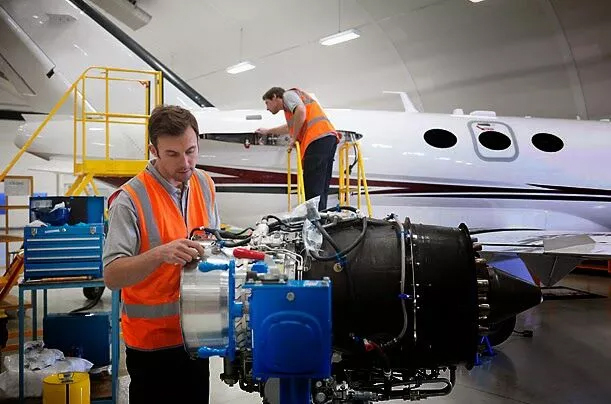 Students seems to be engage in aerospace homework and assignment Two individuals, possibly aerospace engineering students, repairing an airplane engine in a hangar