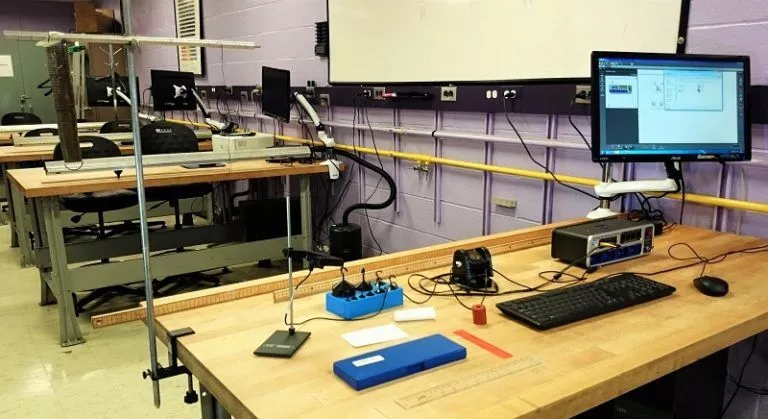 Exploring General Physics: Classroom Setup for Homework Help A classroom equipped with desks and computers on the wall, hosting a general physics homework help session