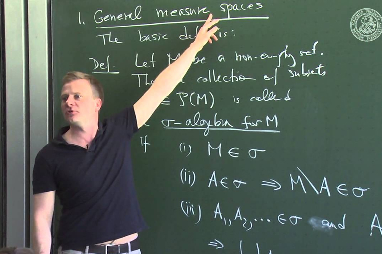 Mastering Measure Theory: Tutoring for Homework and Assignments Help A tutor explaining measure theory concept on a blackboard with mathematical equations. Assisting with homework and assignments